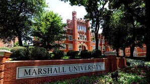 A brick building with a sign reading "MARSHALL UNIVERSITY" surrounded by lush greenery and flowers. - Holiday Inn Express & Suites Ironton by IHG (Ironton)