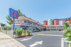 A motel with a blue sign, numbered rooms, and a parking lot. - Motel 6 National City Ca (National City)
