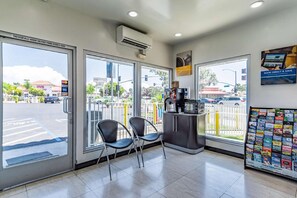 Une pharmacie CVS avec une enseigne indiquant un service ouvert 24 heures sur 24, une machine à café et un présentoir à magazines contenant des guides de voyage.