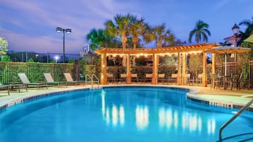 Alberca al aire libre, sombrillas en la alberca y camastros