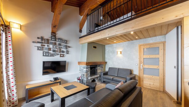 Un salon moderne avec une cheminée, un canapé, un téléviseur et un plafond en bois.