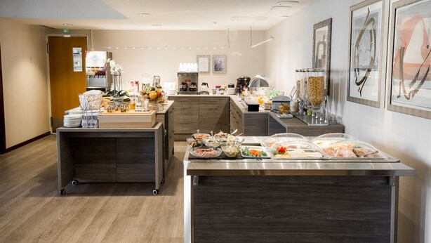 A buffet area with various food stations and a coffee machine. - Hotel Kauppi (Tampere)