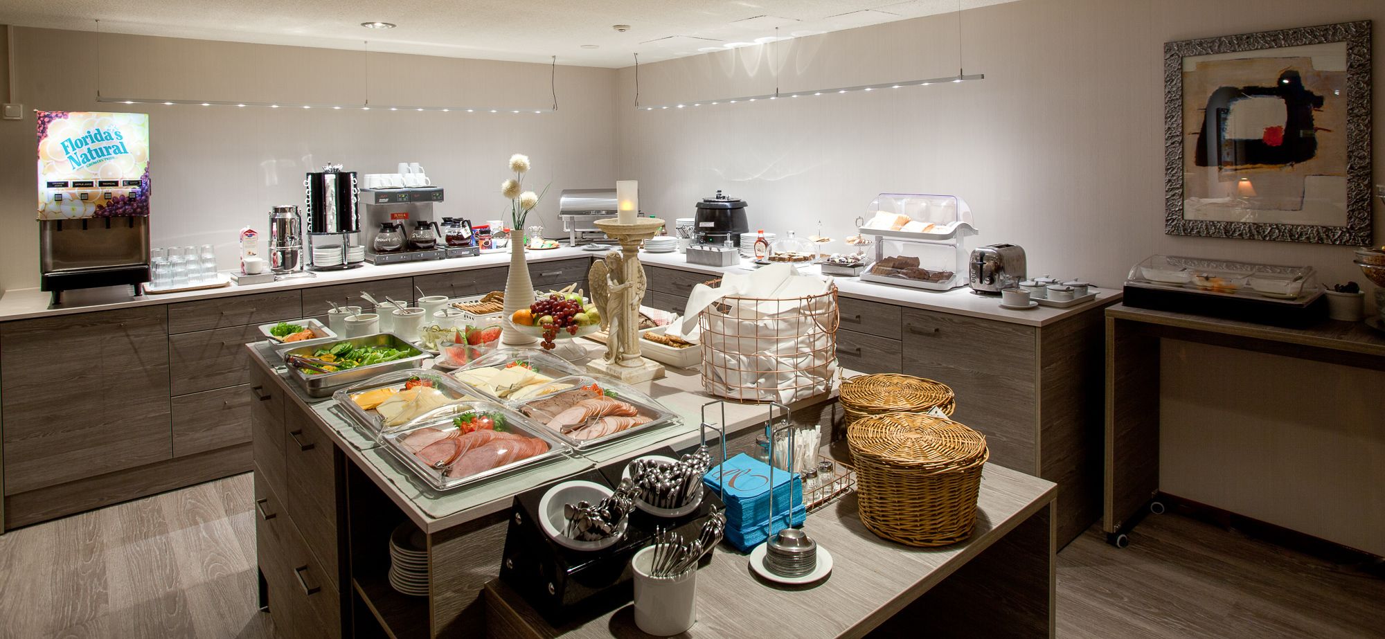 A buffet setup with various food items, a coffee machine, and a refrigerator.