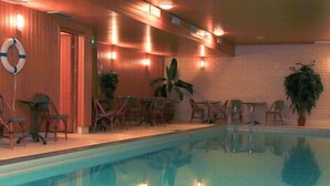 An indoor swimming pool with tiled walls and ceiling, surrounded by wooden walls and furniture. - Hotel Kauppi (Tampere)