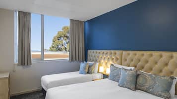Une chambre d’hôtel avec deux lits, une grande fenêtre et une vue sur l’extérieur.