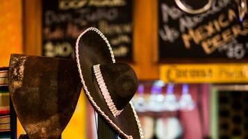 En bar med en rustik inredning, med en hatt på ett stativ och en gammal jukebox i bakgrunden.