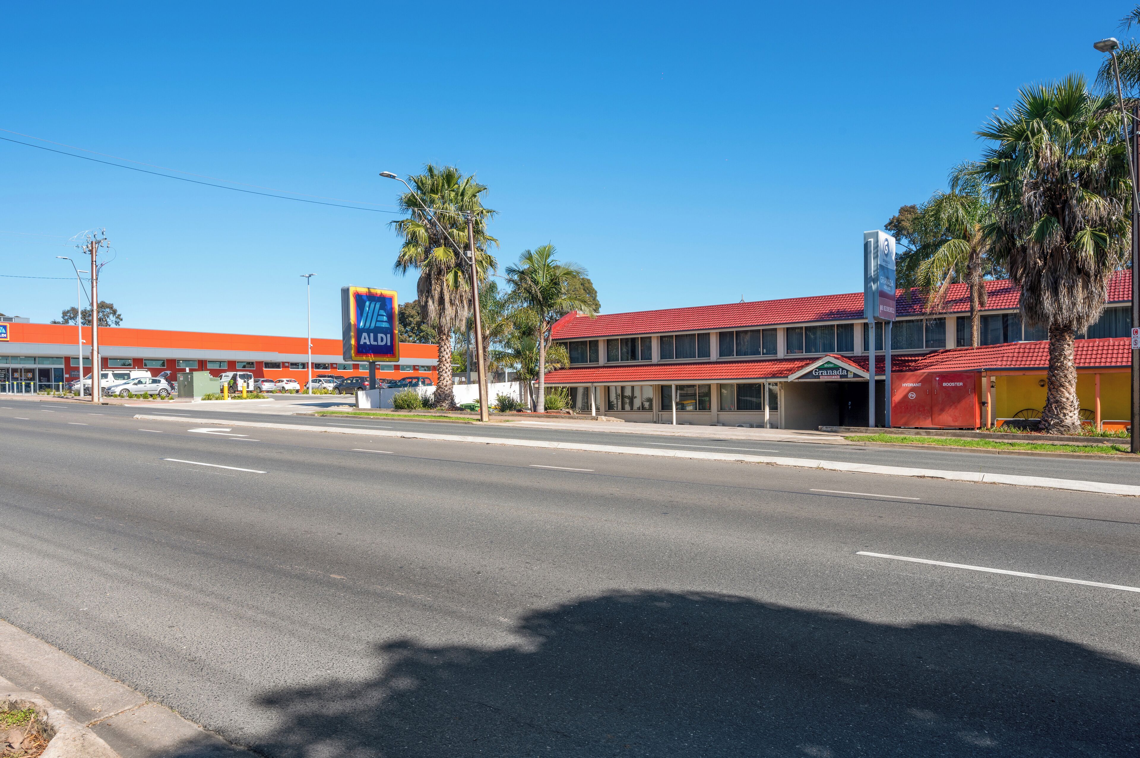 A hotel with a red roof and a sign for a nearby Alltel store.