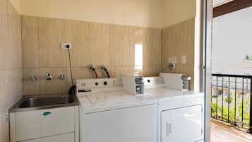 A compact kitchen with a built-in washer and dryer, a sink, and a window providing natural light.