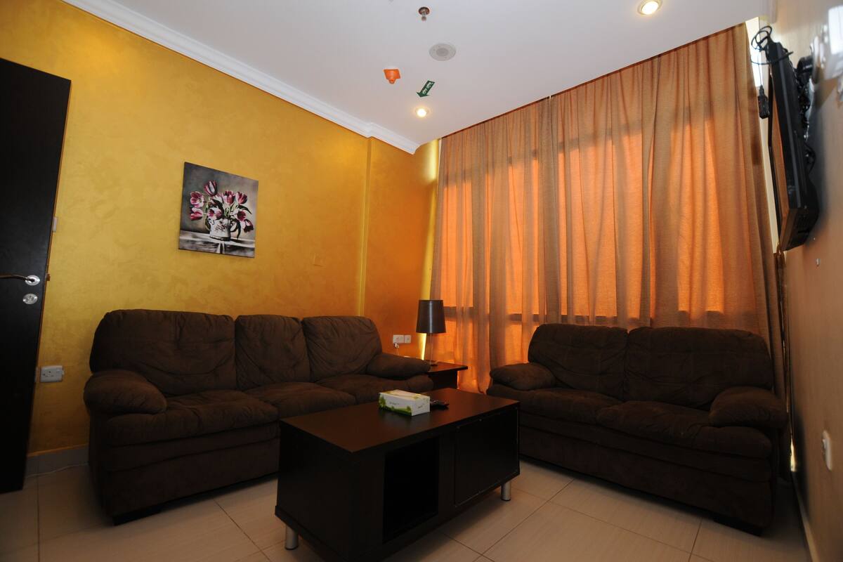 A living room with two sofas, a coffee table, and a painting on the wall.