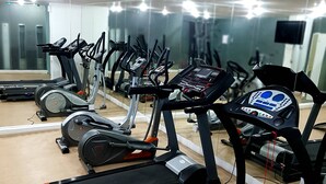 A gym with multiple treadmills, stationary bikes, and a rowing machine. - Al Muhanna Plaza Hotel (Salmiya)