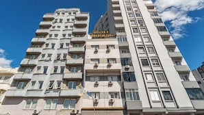 A multi-story hotel with balconies, a visible restaurant, and a clear sky. - Hotel Minuano Express (Porto Alegre)