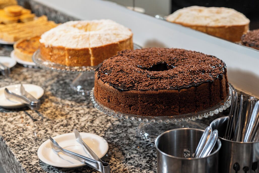A dessert display with various cakes on a granite countertop.