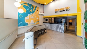 A hotel reception area with a map mural, a counter, and a bench. - Hotel Minuano Express (Porto Alegre)