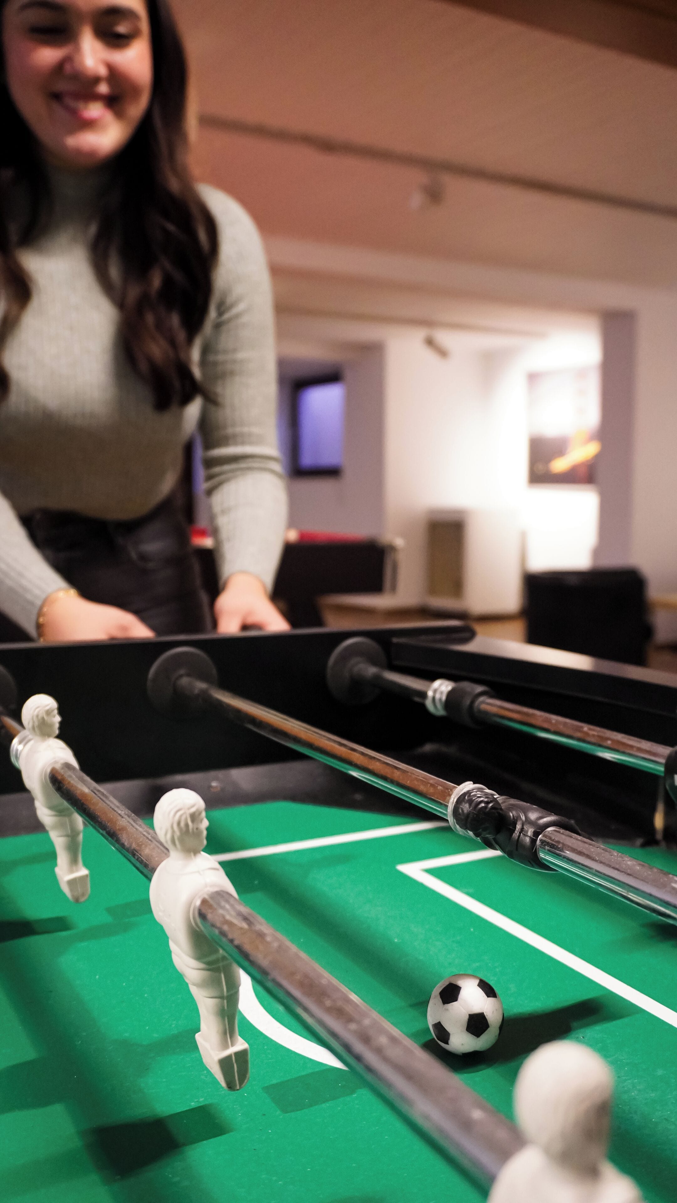 A pool table with a white ball and cue sticks.