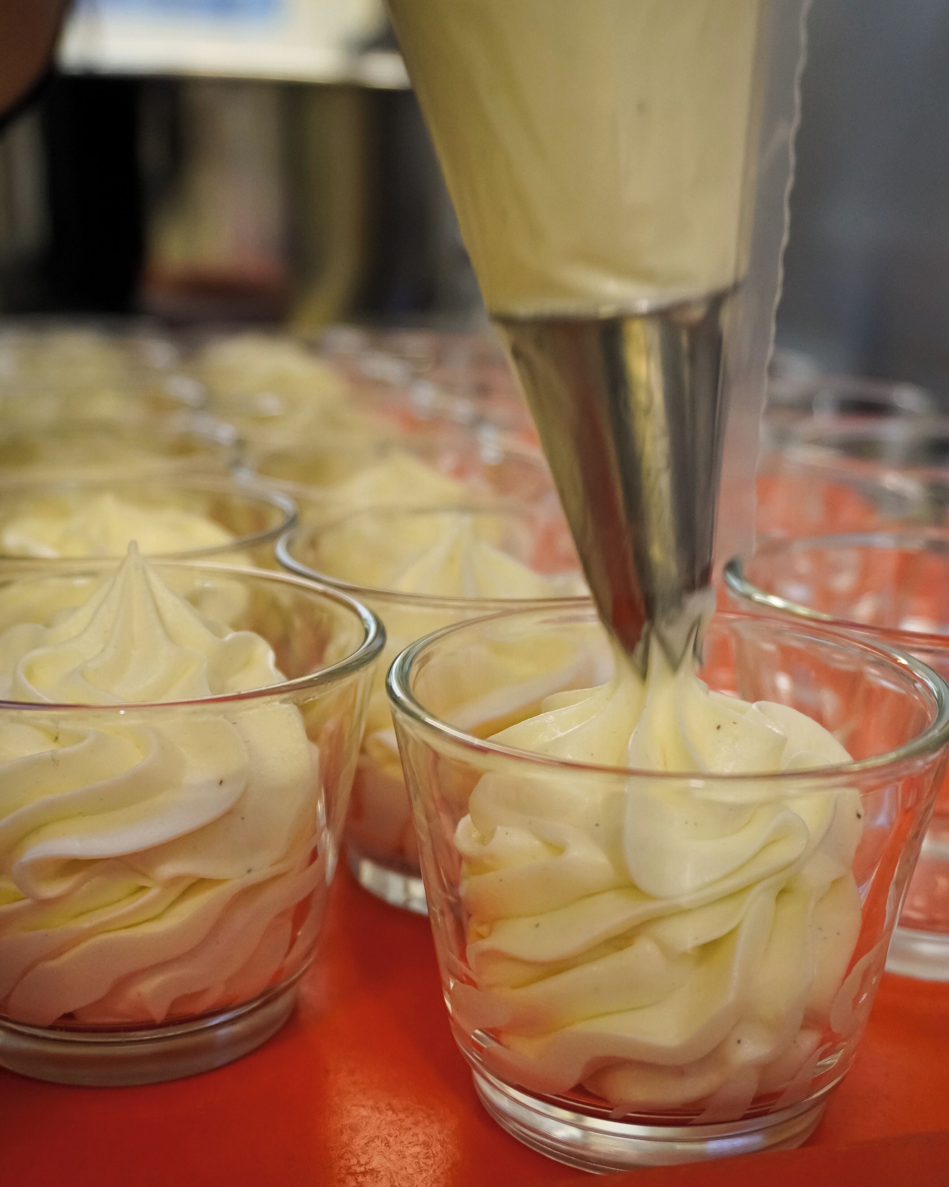 Primer plano de una crema dulce siendo vertida en un vaso.