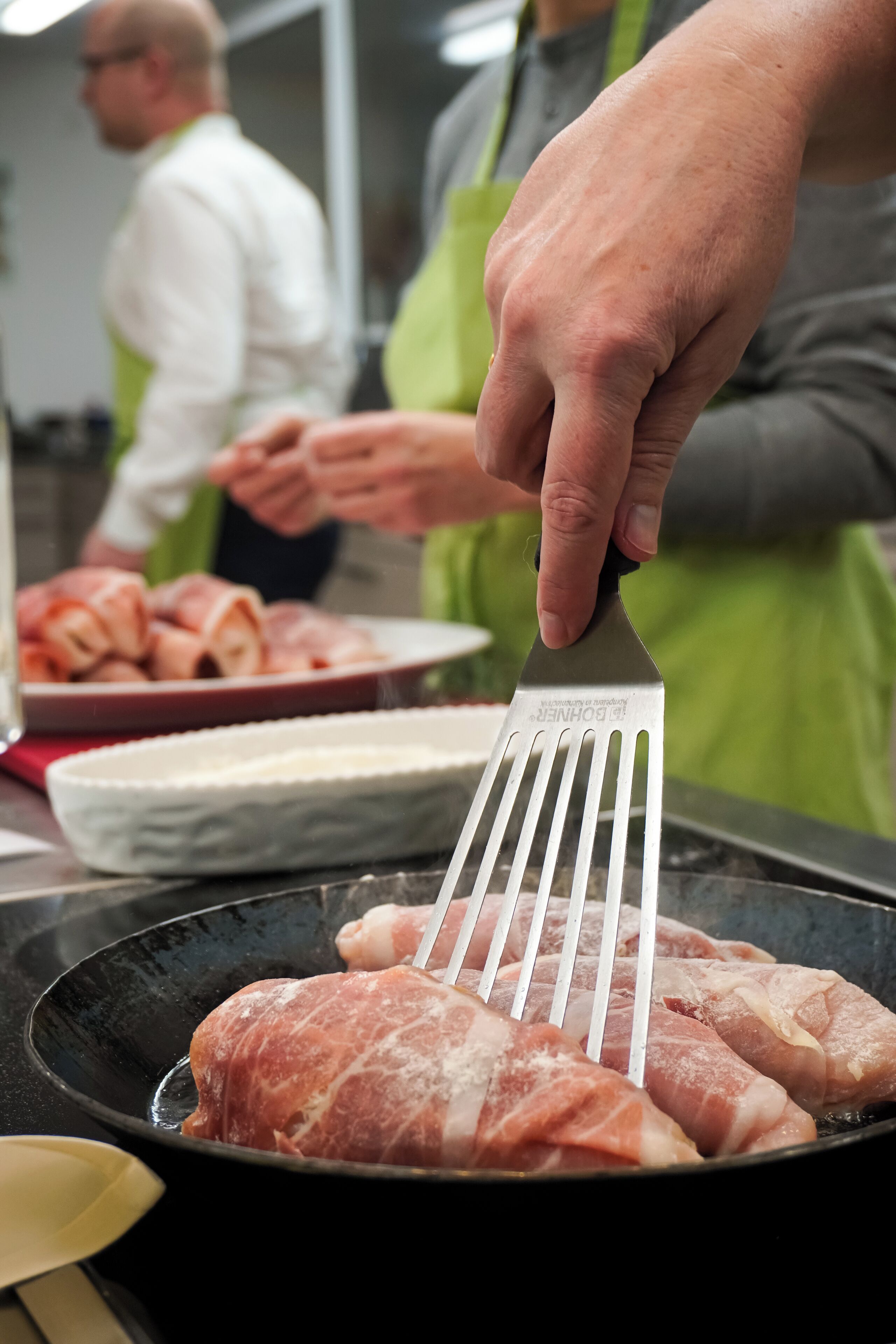 Une personne qui fait griller de la viande dans une poêle.