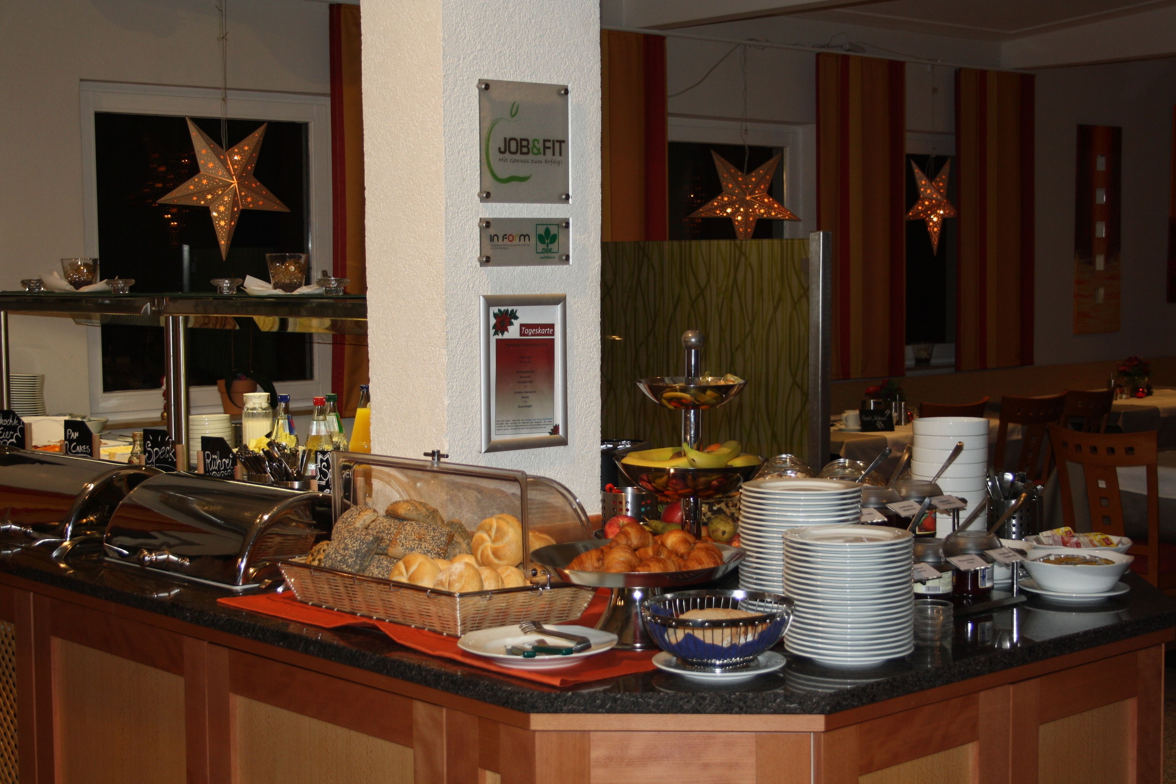 A buffet counter with various food items, a sign for JOB&FIT, and decorative star lights.