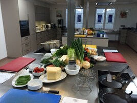 Una cocina moderna con electrodomésticos de acero inoxidable, una variedad de productos frescos y una distribución limpia y ordenada.
