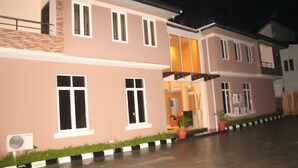 A two-story building with a flat roof, large windows, and a visible entrance. - TOC Hotel (Lekki)
