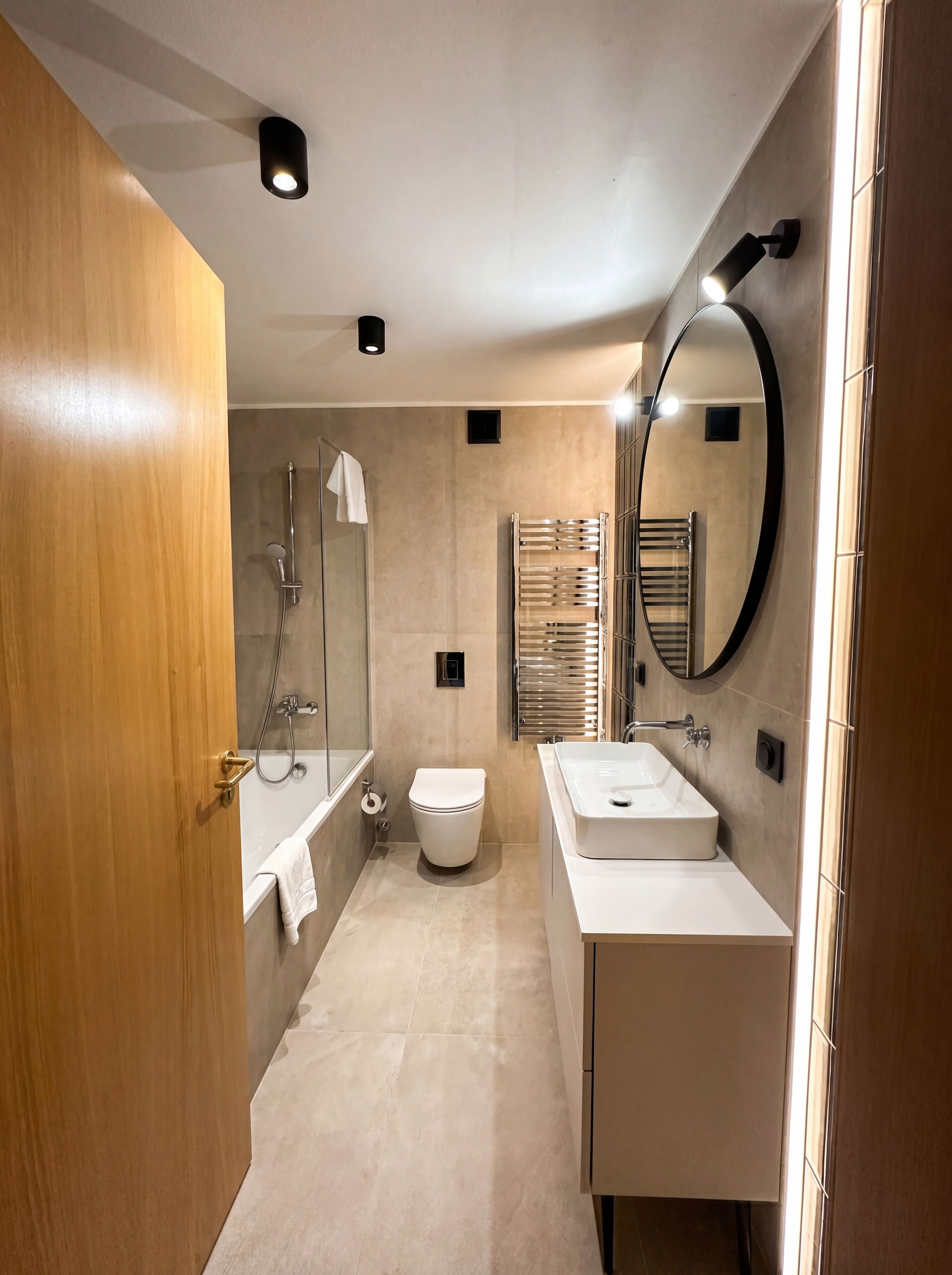 A modern bathroom with a shower, toilet, and two sinks.
