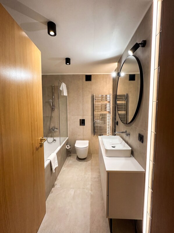 Un baño moderno con ducha, inodoro y dos lavamanos.