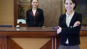 Una mesa de recepción con cubierta de mármol y un letrero que dice 'RECEPCJ'.