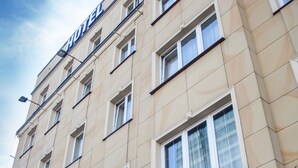 Un hotel con un letrero que dice "SZYDŁOWSKI HOTEL" y una entrada cubierta.