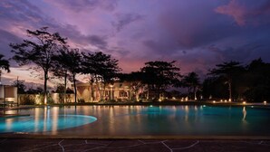 A swimming pool at dusk with a building in the background. - Samanea Beach Resort & Spa (Kep)
