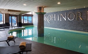 A modern indoor swimming pool with lounge chairs and a view of mountains through large windows. - Résidence Koh-I Nor by Les Etincelles (Les Belleville)