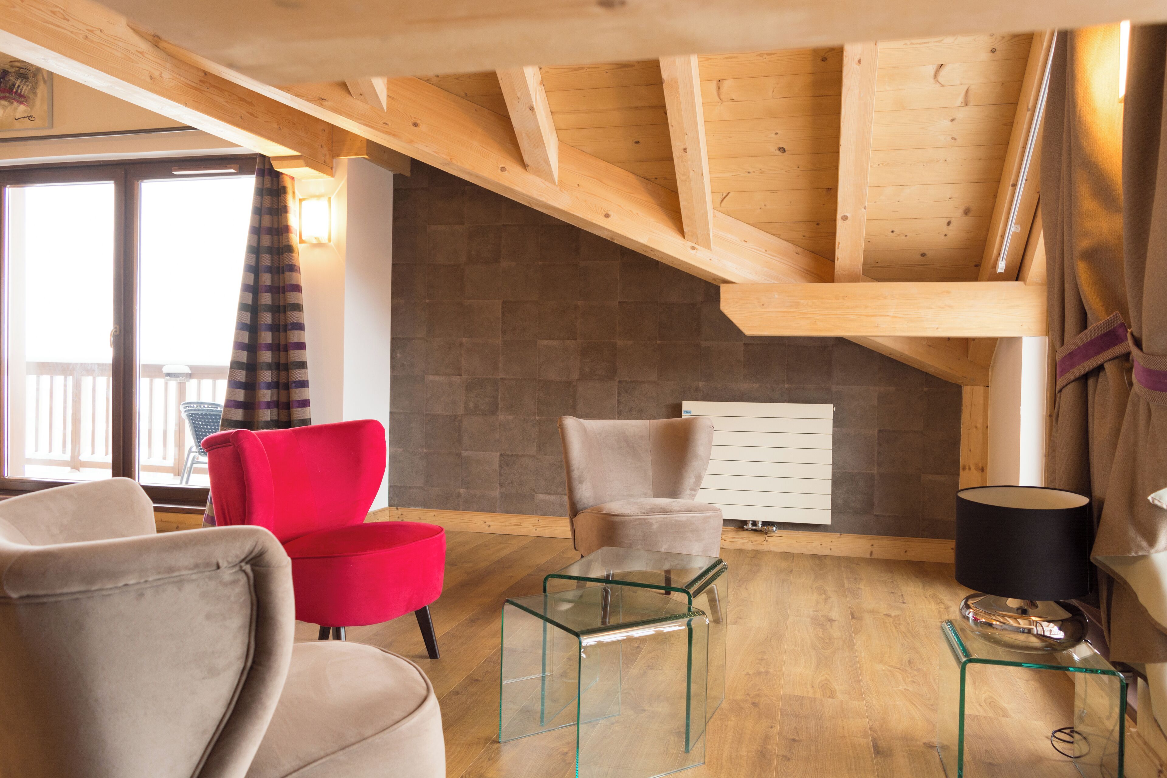 Een moderne woonkamer met houten balken, een open haard en twee stoelen.