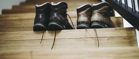 A pair of shoes on a wooden staircase.