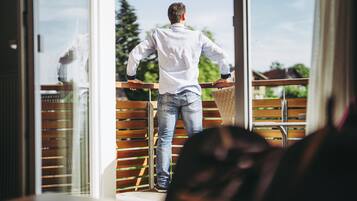 A person standing at a balcony railing, looking out.