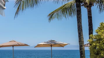 Una piscina al aire libre, sombrillas, sillones reclinables de piscina
