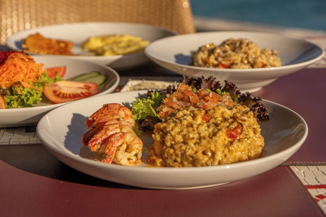 A table with various dishes including seafood, vegetables, and a bowl of lentils.