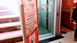 A hostel entrance with a sign advertising activities like walking tours and bike tours. - Home Backpackers Valencia by Feetup Hostels (Valencia)