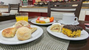 A breakfast setting with pastries, a glass of orange juice, and a cup of coffee on a table. - Oyo Uniclass Hotel Centro SP (Sao Paulo)