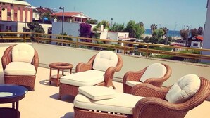 A rooftop terrace with wicker furniture and a view of the sea. - Hotel Royal (Vasto)