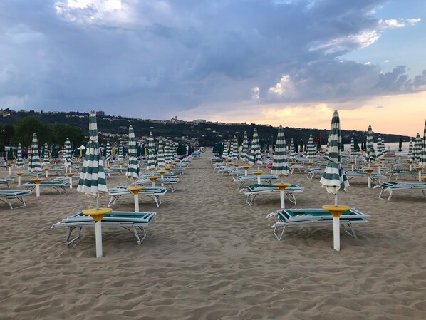 Aan een privéstrand, ligstoelen, parasols