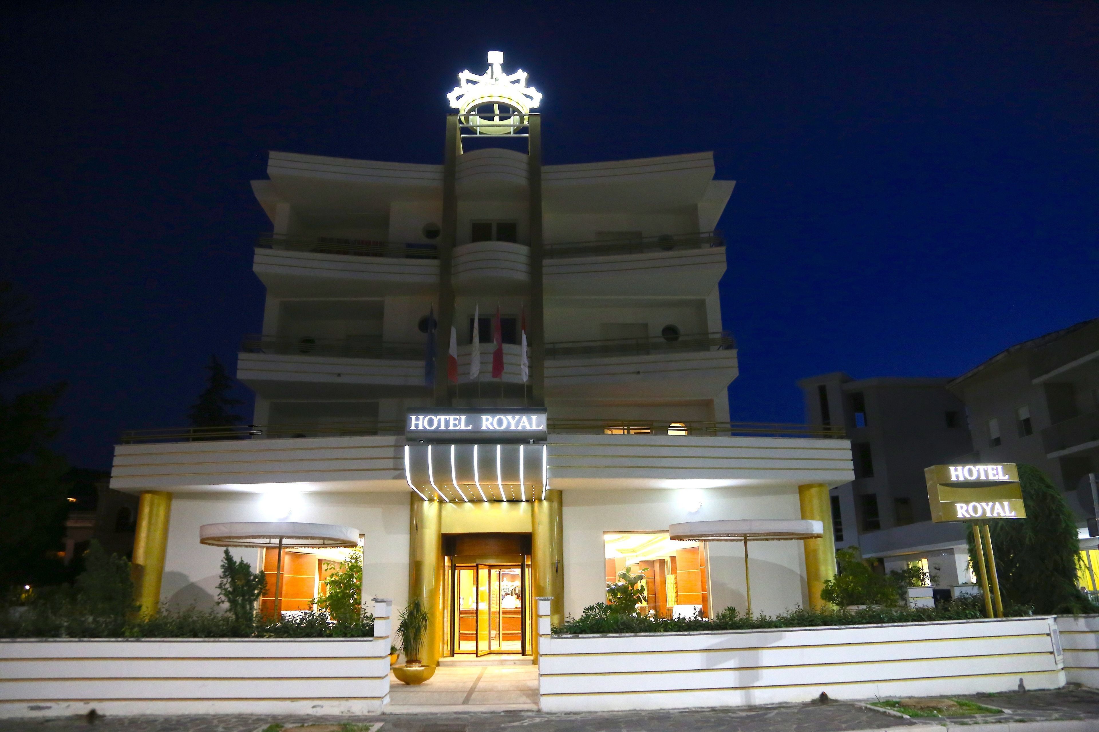 A multi-story building with a prominent crown symbol on top, labeled "HOTEL ROYAL".