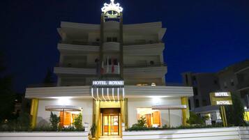 A multi-story building with a prominent crown symbol on top, labeled "HOTEL ROYAL".