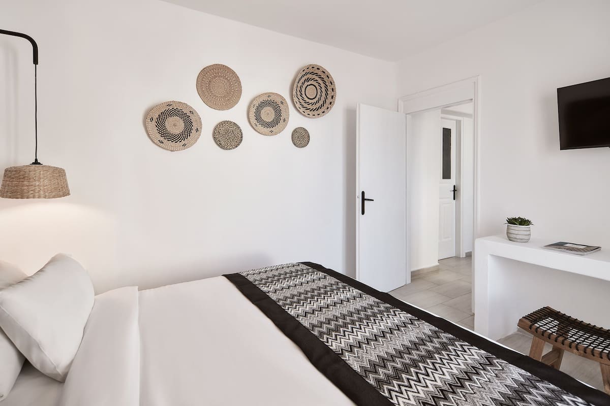 Une chambre d’hôtel moderne équipée d’un lit, d’un bureau et d’une télévision.