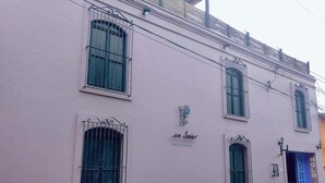 Um edifício rosa com janelas protegidas por grades e uma placa com o nome 'La Luna'.