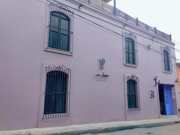A pink building with barred windows and a sign that reads "La Luna". - Un sueno Valle de Huajes (Oaxaca)