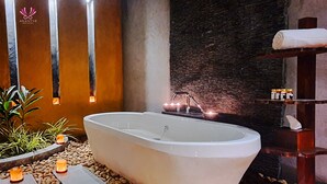 Un baño moderno con una bañera independiente, un estante de madera con artículos de aseo y un perchero en la pared.