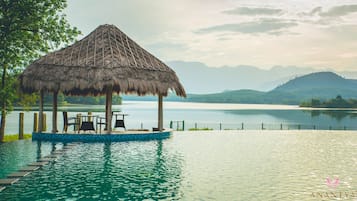 Una piscina al aire libre, sillones reclinables de piscina