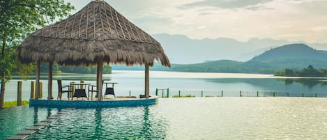 Una piscina al aire libre, sillones reclinables de piscina