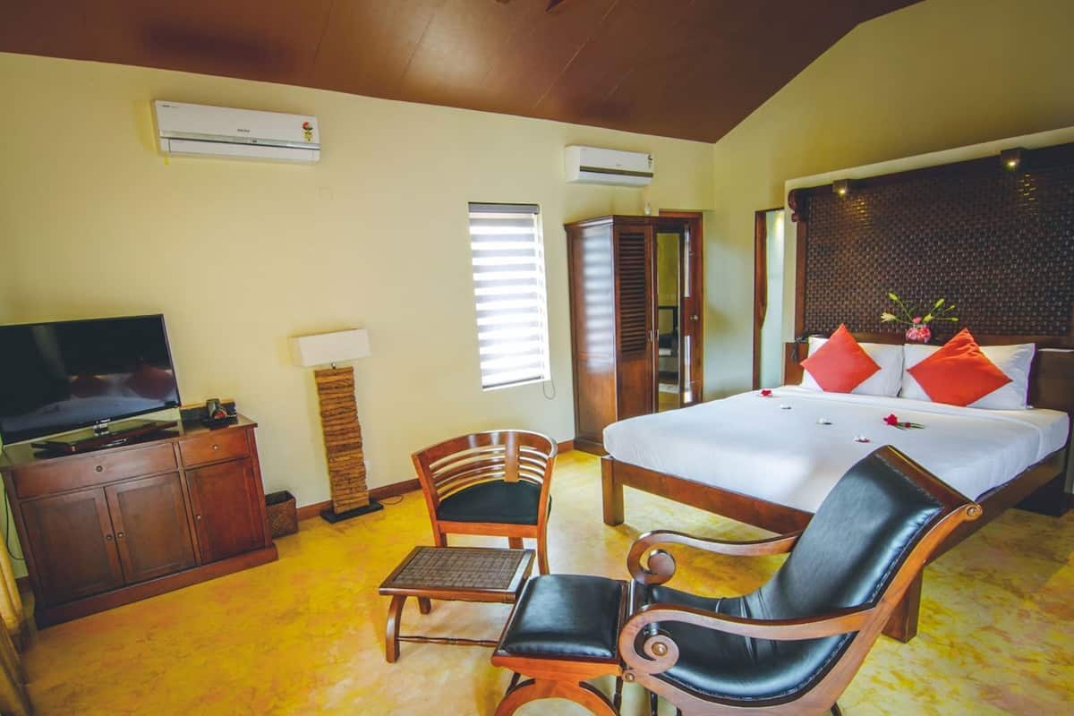 A hotel room with a bed, a TV, a desk, and a chair.