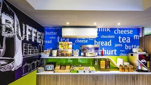 A breakfast bar with a variety of food items and a wall with food-related words.