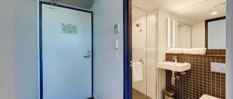 A modern bathroom with a shower, toilet, and sink.