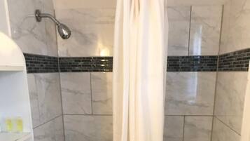 A bathroom with a bathtub, a shower, and a toilet.